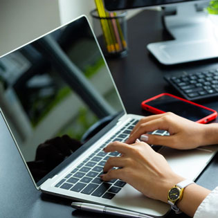 personne pianotant sur le clavier d'un ordinateur portable